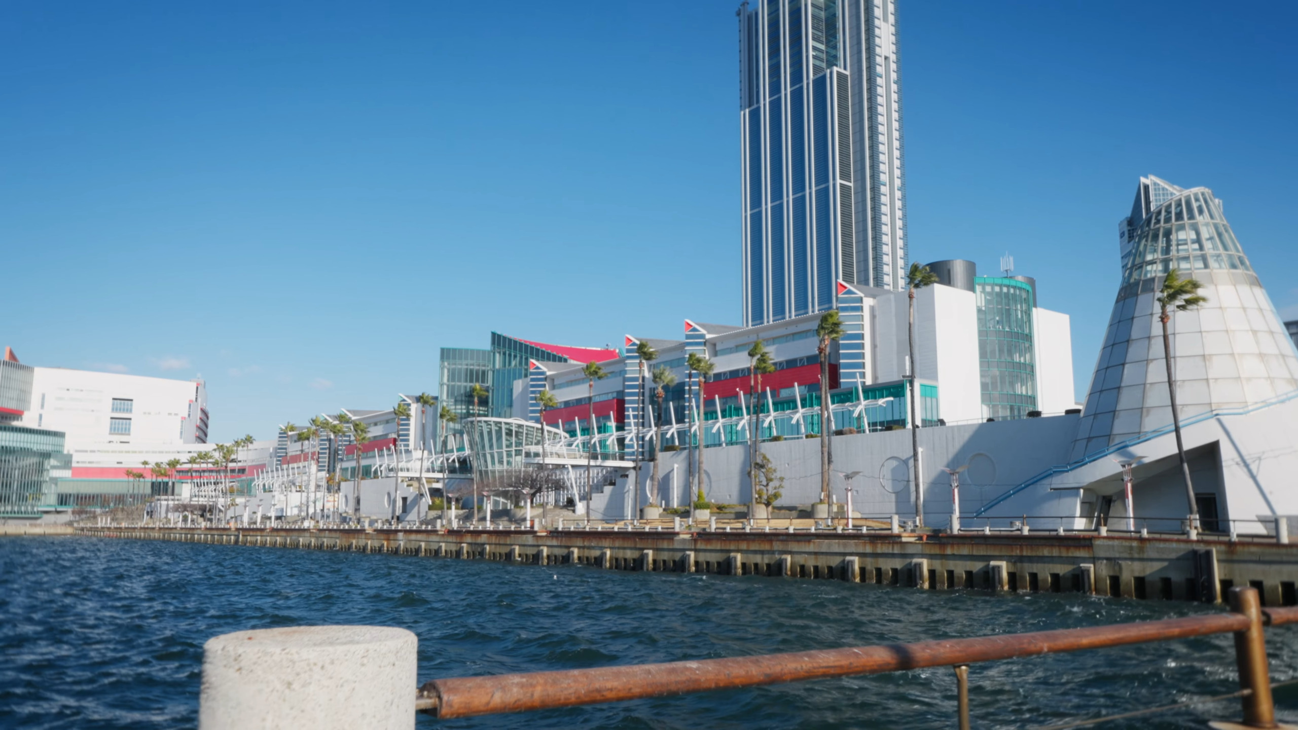春の青空の下、海に面したATCの外観