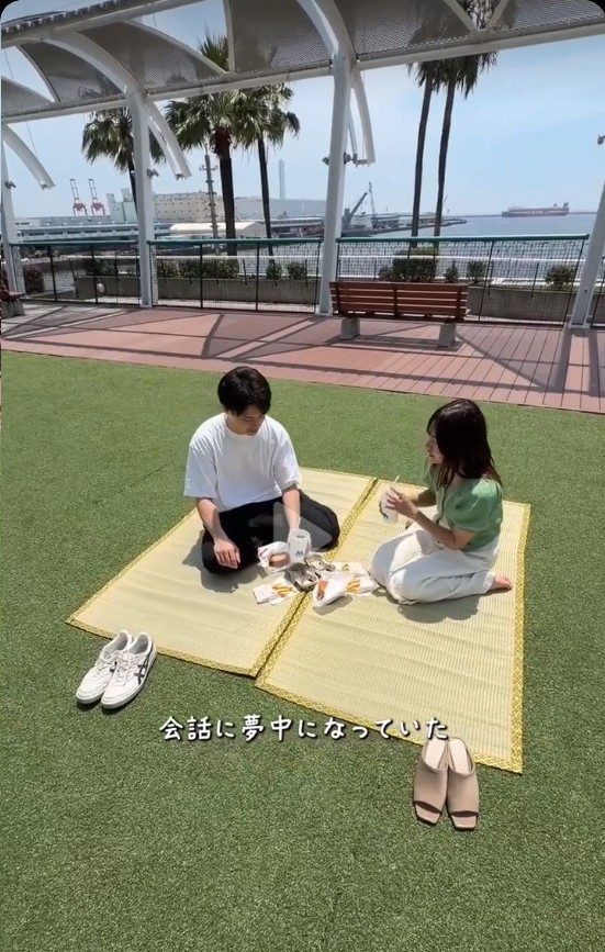 ゴザの上で向かい合い、会話を楽しむふたり。手前には脱いだ靴が並んでいる