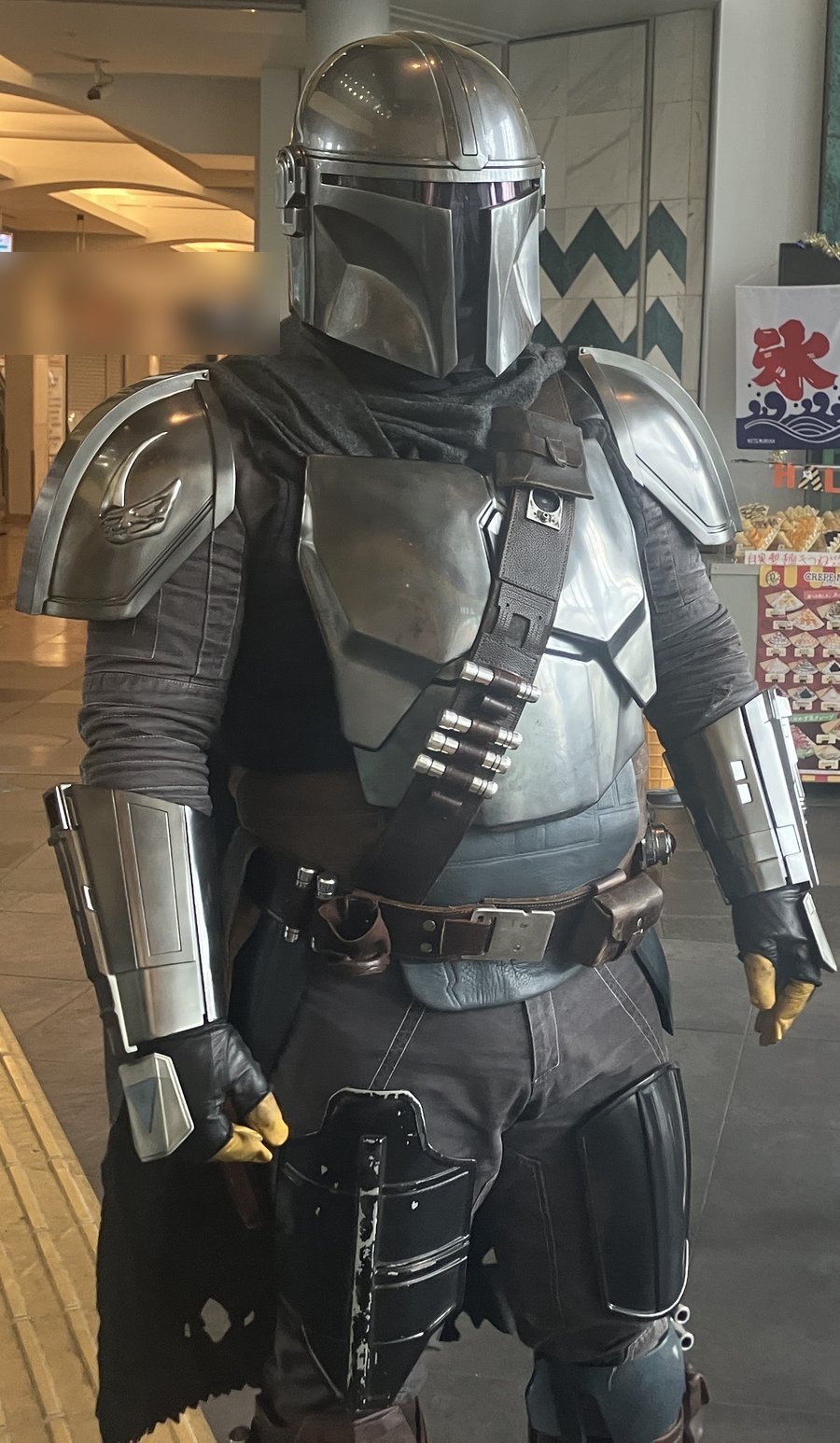 館内に立つ、銀色の鎧とヘルメットのコスチューム姿の方