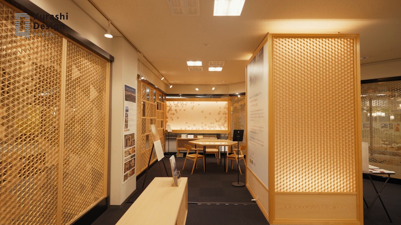 ショールームの展示。木の格子を組んだ仕切りが、内側からの明かりで暖かく光り、奥にはテーブルとイスが置かれている